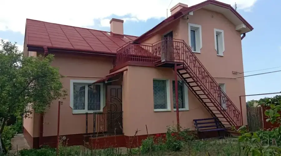 Приватний будинок із пофарбованим вишнево-червоним дахом